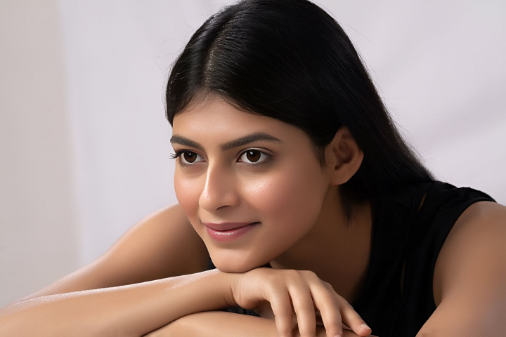 Aiswariya Sinha resting her chin on her hands, with a quiet, thoughtful gaze — symbolizing silent dreams and a peaceful strength.