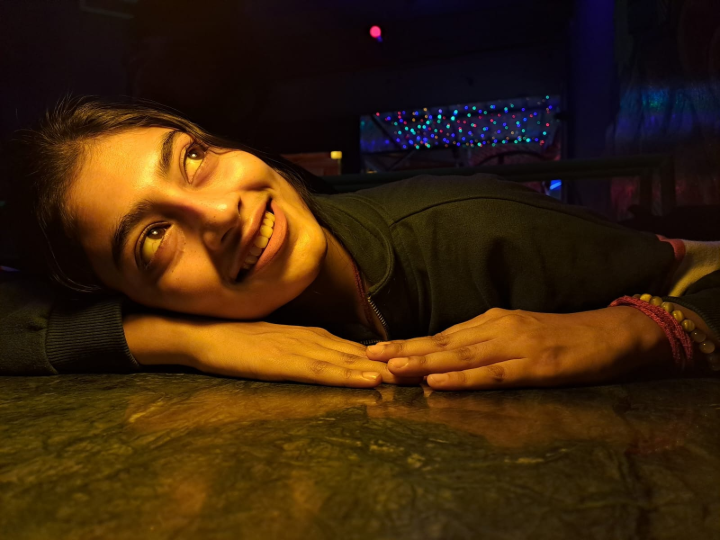 Aiswariya Sinha smiling warmly with her head resting on folded hands, reflecting on her mother’s unwavering support.