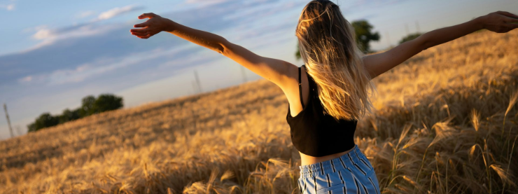Seraphina Vale – The Soul of The Pink Story. Seraphina Vale, Co-Founder of The Pink Story, embracing freedom and creativity in a golden wheat field.
